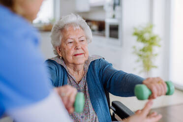Krankenschwester übt mit einer älteren Frau in ihrem Haus, Konzept der Gesundheitsfürsorge und Rehabilitation. - HPIF32864