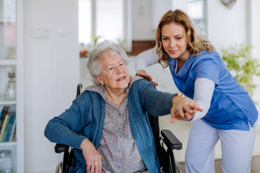 Krankenschwester übt mit einer älteren Frau in ihrem Haus, Konzept der Gesundheitsfürsorge und Rehabilitation. - HPIF32868