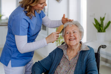 Young nurse doing hairstyle to her senior woman client. - HPIF32875