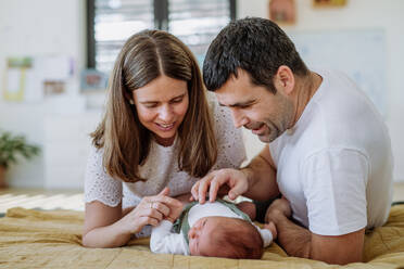 Glückliche Eltern, die mit ihrem neugeborenen Sohn kuscheln. - HPIF32995