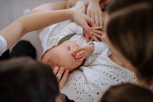 Porträt einer Frau, die ihr neugeborenes Baby küsst, andere Geschwister streicheln es. - HPIF33002