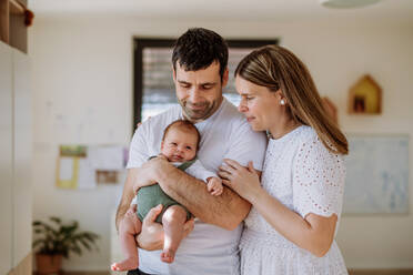 Happy parents cuddling with their newborn son. - HPIF33026