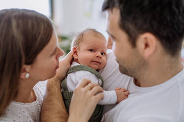 Glückliche Eltern, die mit ihrem neugeborenen Sohn kuscheln. - HPIF33029