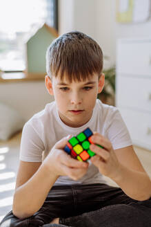 Little boy playing with Rubiks cube at home. - HPIF33051