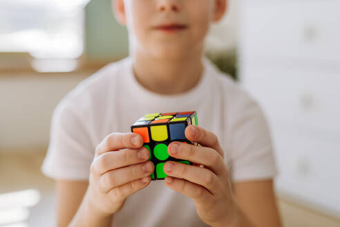 Little boy playing with Rubiks cube at home. - HPIF33053