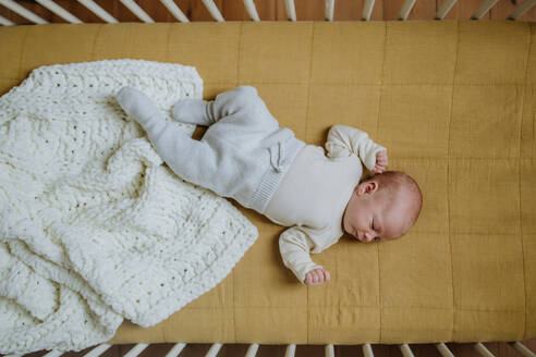 Hohe Winkelansicht des schlafenden Neugeborenen im Bettchen. - HPIF33061