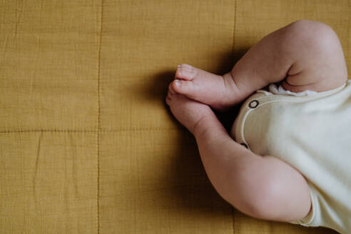 Nahaufnahme der Beine eines Babys in einem Bett. - HPIF33071