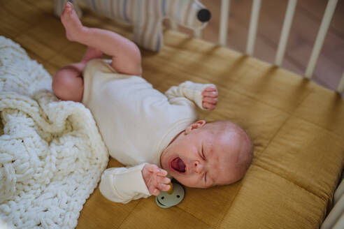 Hohe Winkelansicht des schlafenden Neugeborenen im Bettchen. - HPIF33078