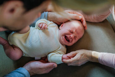 Close-up of parents cuddling their newborn crying son. - HPIF33109