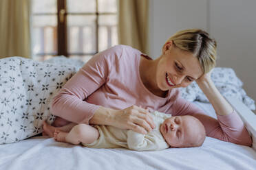 Mutter kuschelt mit ihrem neugeborenen Baby im Bad. - HPIF33126