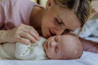 Mother cuddling with her newborn baby in the bad. - HPIF33127