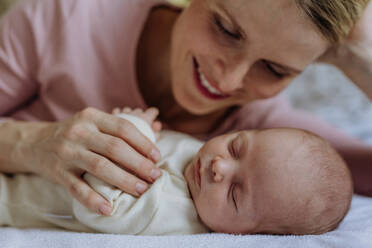 Mother cuddling with her newborn baby in the bad. - HPIF33129