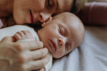 Nahaufnahme einer Mutter, die mit ihrem neugeborenen Baby im Bad kuschelt. - HPIF33130