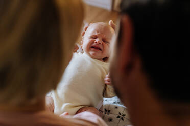 Close-up of parents cuddling their newborn crying son. - HPIF33140