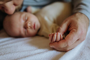 Close up of father holding hand of the newborn baby. - HPIF33149