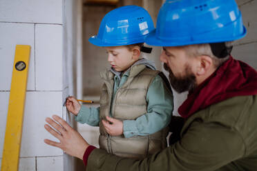 Father and his little son working together on their unfinished house. - HPIF33199