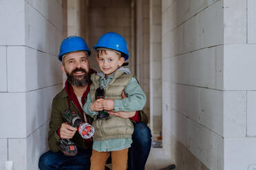 Father and his little son working together on their unfinished house. - HPIF33202