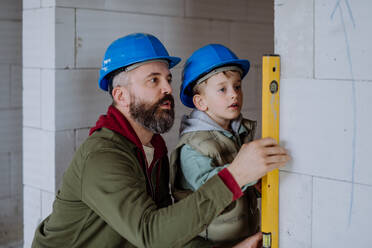 Father and his little son working together on their unfinished house. - HPIF33207