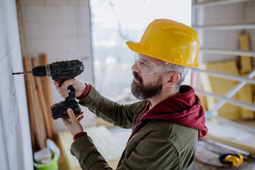 Mature man working in his unfinished house. - HPIF33222