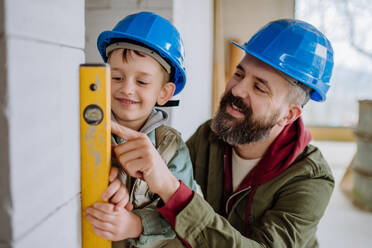 Father and his little son working together on their unfinished house. - HPIF33236