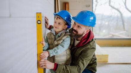 Father and his little son working together on their unfinished house. - HPIF33239