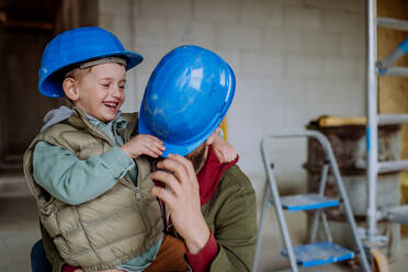 Father and his little son having fun in their unfinished home. - HPIF33244