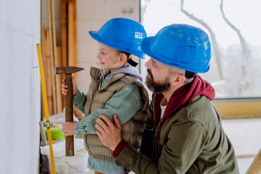 Father and his little son working together on their unfinished house. - HPIF33249