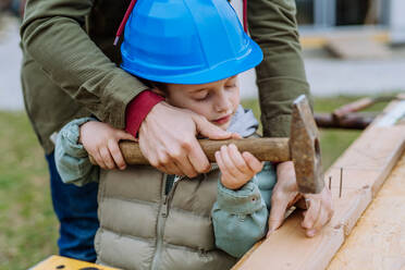 Close- up of father and his little son working outdoor with wooden panicle. - HPIF33272