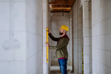 Portrait of mature man working in his new unfinished house. - HPIF33284