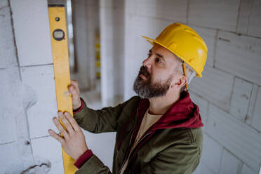 Portrait of mature man working in his new unfinished house. - HPIF33285