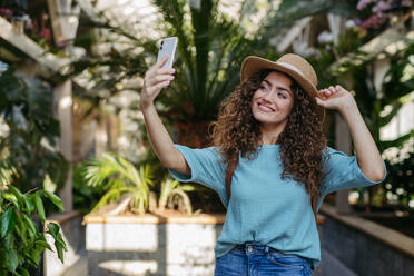 Young woman in a botanical garden taking selfie, concept of tourist and holiay. - HPIF33325