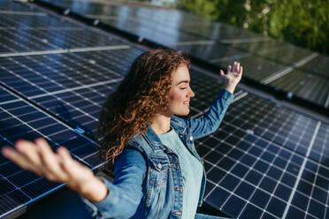 Portrait of young woman, owner on roof with solar panels. - HPIF33343