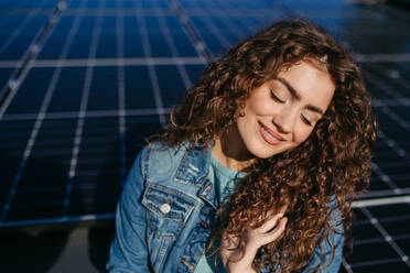 Portrait of young woman, owner on roof with solar panels. - HPIF33344