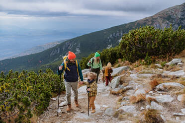 Glückliche Familie beim gemeinsamen Wandern in den herbstlichen Bergen. - HPIF33521
