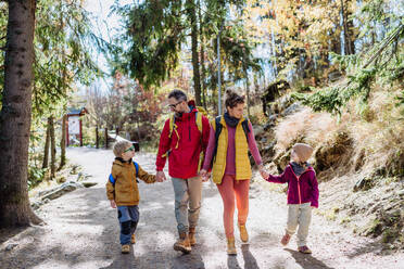 Porträt einer glücklichen Familie, die gemeinsam in den herbstlichen Bergen wandert, mit kleinen Kindern auf einem kinderfreundlichen Weg. - HPIF33563