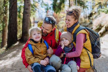 Porträt einer glücklichen Familie, die gemeinsam in den herbstlichen Bergen wandert, mit kleinen Kindern auf einem kinderfreundlichen Weg. - HPIF33565