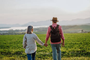 Älteres Ehepaar bei einem Spaziergang durch die herbstliche Natur. Ältere Eheleute genießen die schöne Aussicht auf die Hohe Tatra. Pilzjagd, Pilzsuche oder Pilzsammeln. - HPIF33585