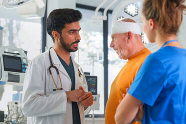 Young doctor and nurse consulting health condition with injured senior man. - HPIF33792