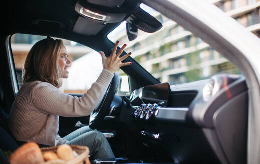 Upset woman driving her car in city. - HPIF33800