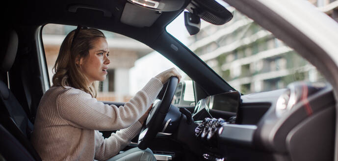 Upset woman driving her car in city. - HPIF33801