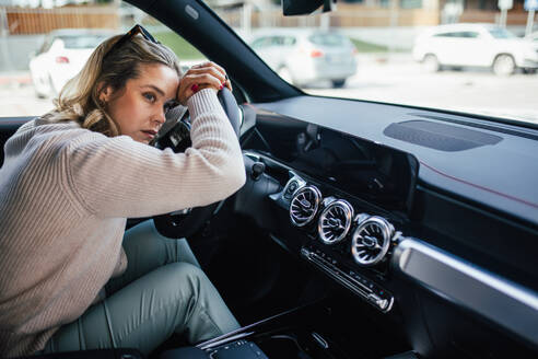 Portrait of young tired woman sleeping in a car, concept of safety and driving. - HPIF33805