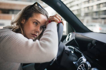 Upset woman driving her car in city. - HPIF33806