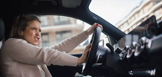 Upset woman driving her car in city. - HPIF33808