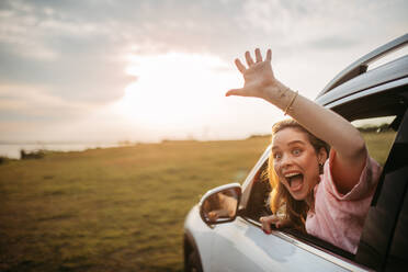 Happy woman driving her new electric car in a city. - HPIF33835