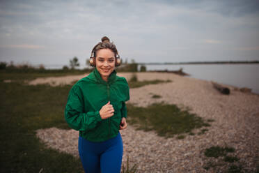 Young woman runing outdoor, near a lake. - HPIF33857