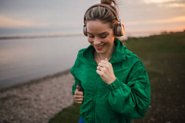 Young woman runing outdoor, near a lake. - HPIF33860