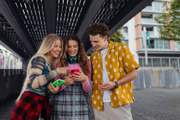 Generation z students hanging out together outdoors in the city. Young stylish zoomers are online, using smartphones, social media, taking selfies. Concept of power of friendship and social strength of gen Z. - HPIF33868