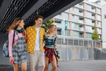 Generation z students hanging out together outdoors in the city. Young stylish zoomers are online, using smartphones, social media, taking selfies. Concept of power of friendship and social strength of gen Z. - HPIF33870