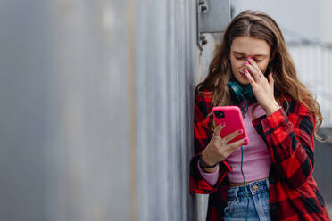 Gen Z girl outdoors in the city, feeling sad and anxious. Young zoomer student is alone. Concept of gen Z as loneliest generation. - HPIF33888