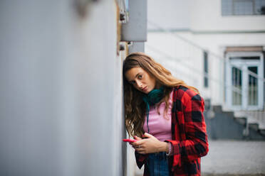 Gen Z Mädchen draußen in der Stadt, traurig und ängstlich. Junge Zoomer-Studentin ist allein. Konzept der Gen Z als einsamste Generation. - HPIF33889